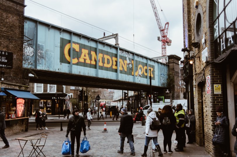 Camden lock sign on train bridge in London. Cow & Co estate agency in London